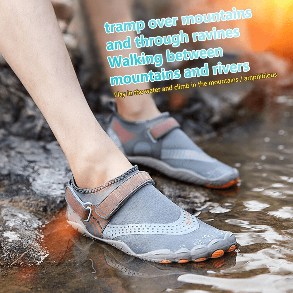 Person wearing gray unisex nonslip aquatic sneakers with hook & loop closure, walking through water and rocks.